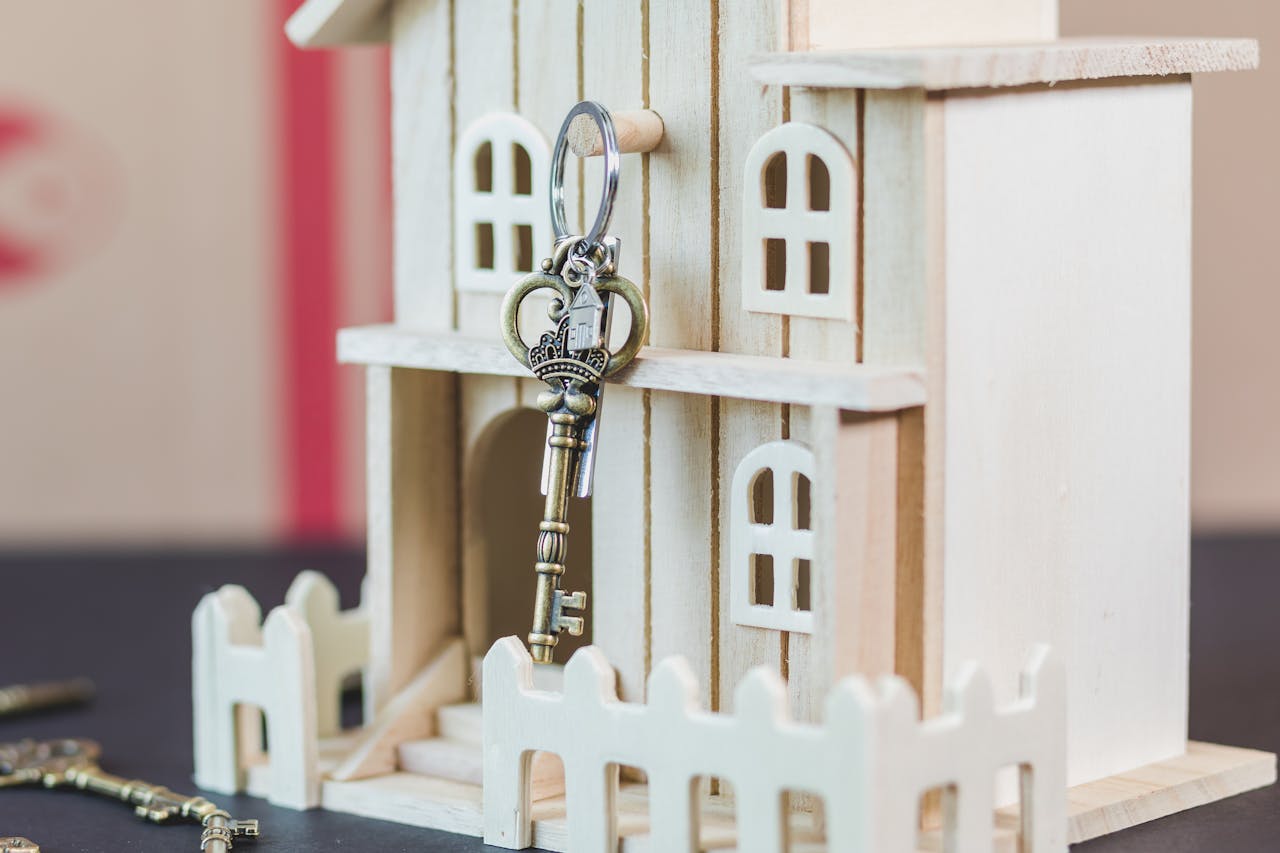 Ein Holzhaus Modell mit einem alten Schlüssel. Steht Symbolisch für die Schlüsselübergabe